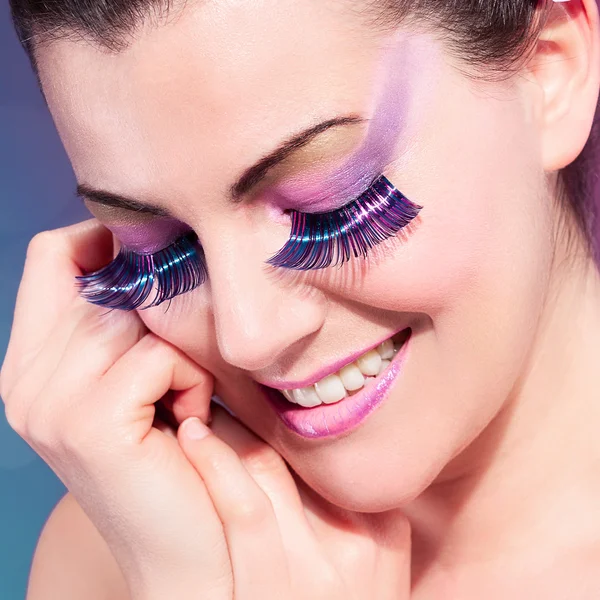 Femme souriante avec des cils colorés — Photo