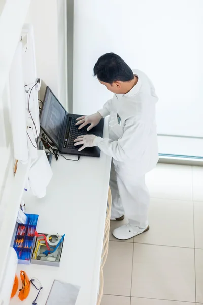 Dentista asiático trabalhando em um computador — Fotografia de Stock