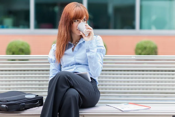 Бізнес-леді сидить надворі на металевій лавці — стокове фото