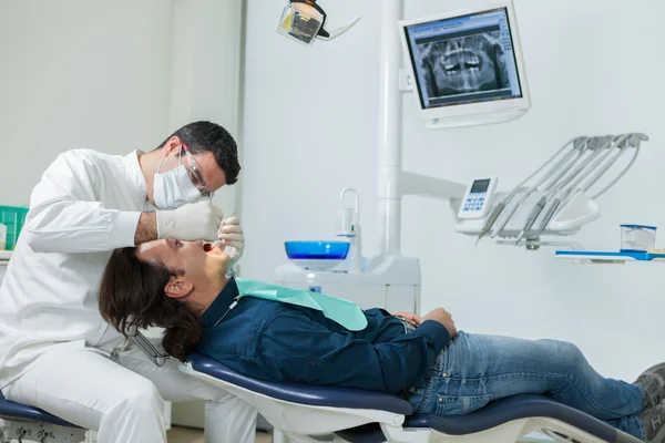 Dentist is doing a checkup on a 40 years old man — Stock Photo, Image