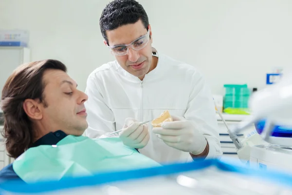 Il dentista sta mostrando un modello in gesso al suo paziente — Foto Stock