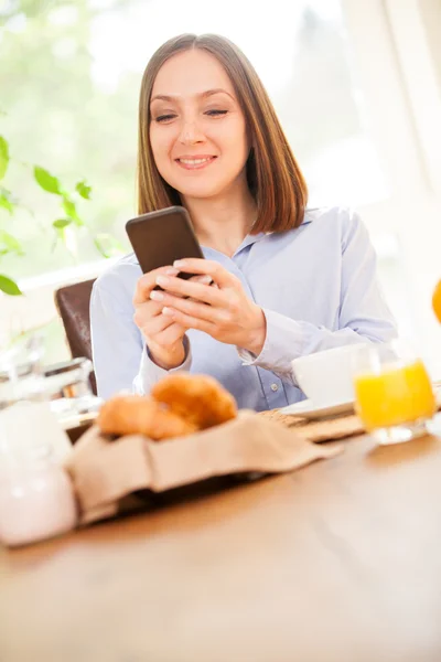 Geschäftsfrau frühstückt, während sie E-Mails checkt — Stockfoto
