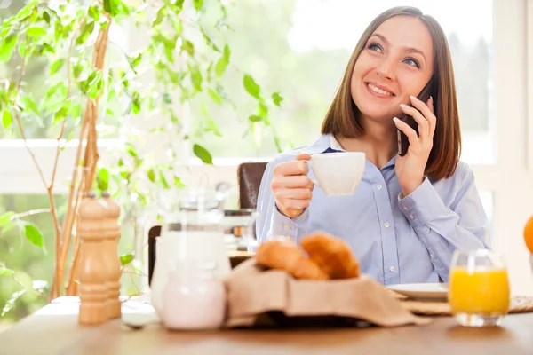 Businesswoman is phoning while having breakfast — Stock Photo, Image