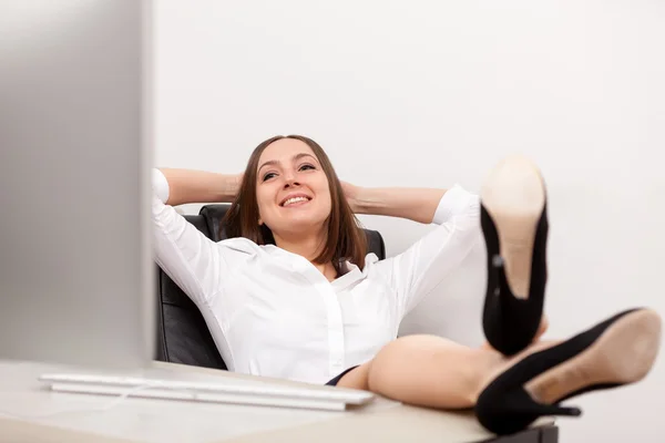 Ontspannen zakenvrouw op haar Bureau — Stockfoto