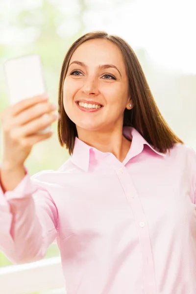 Mulher com camisa rosa está fazendo uma selfie — Fotografia de Stock