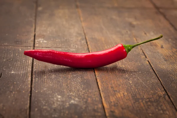 Spicy red pepper over old table — Stock Photo, Image