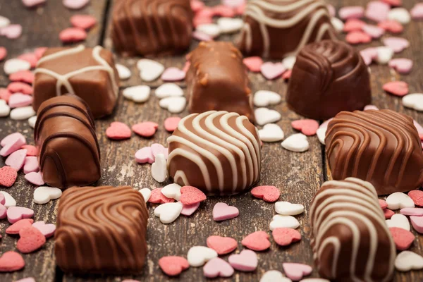 Chocolate pralines over wooden table — Stok fotoğraf