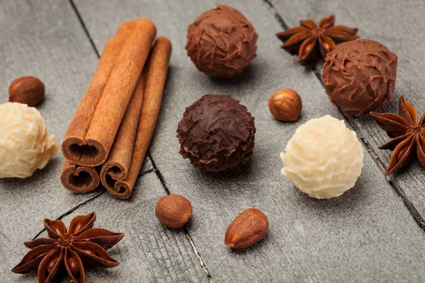 Schokoladentrüffel und Gewürze über Holztisch — Stockfoto