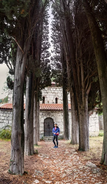 Menina turista no território do antigo castelo marco no beco com ciprestes — Fotografia de Stock