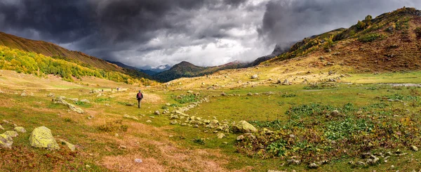 Pár túrázók pihenjen, és élvezze a gyönyörű panorámát a hegységek. — Stock Fotó