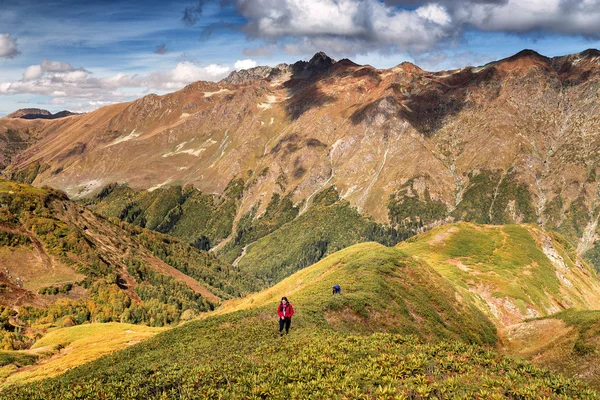 Un grupo de turistas bajando la colina en las montañas del Cáucaso en otoño — Foto de Stock