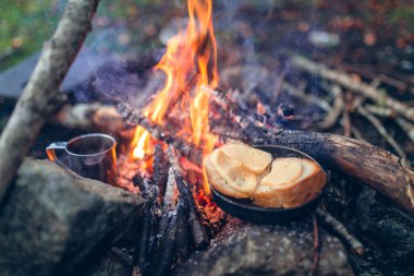 Peynir ve ekmek metal tava ateşe kavrulmuş. Açık kavramı ve gıda ve snack hiking. Bir retro vintage Instagram stil filtresiyle bitmiş etkisi tonlama