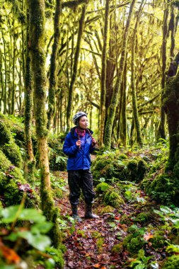 Genç kadın sırt çantası ve kask ile seyahat mavi ceketli. Abhazya.