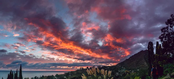 Montañas panorámicas ciudad al atardecer con cielo púrpura y mar — Foto de Stock