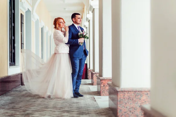 Retrato de boda de una novia y un novio al aire libre entre columnas — Foto de Stock