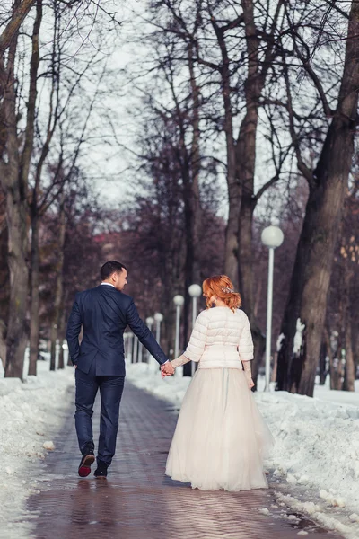 Prachtige elegante luxe bruid en stijlvolle bruidegom knuffelen en wandeling — Stockfoto