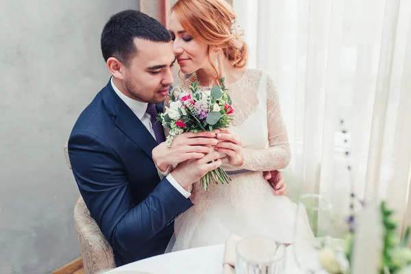 Ritratto di coppia appena sposata con mazzo di fiori al chiuso — Foto Stock