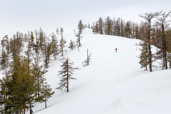 Winterlandschaft mit einsamen Skifahrern am Berg — Stockfoto