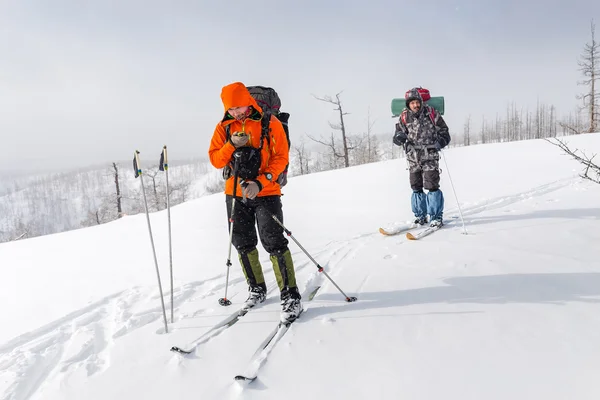 Vista de alta altitude de dois esquiadores caminhando em um cume de montanha em — Fotografia de Stock
