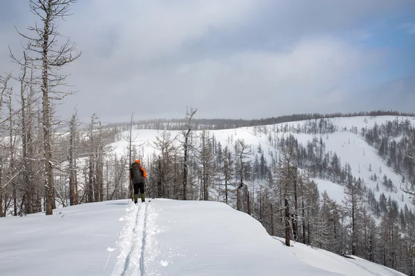 Trilhas de esqui homem com mochila em montanhas nevadas Ridge — Fotografia de Stock