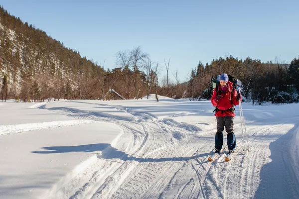 Chica esquiando en un paseo de invierno con un teléfono en la mano — Foto de Stock