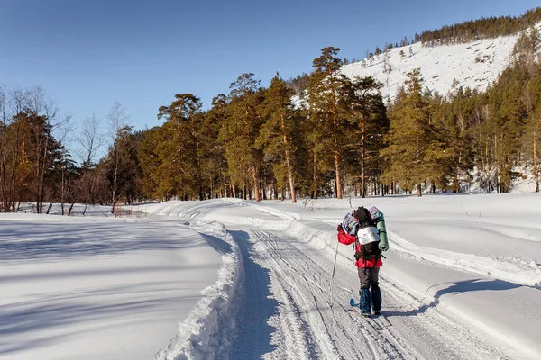 Uma mulher cruzar o país esquiando através de um lago congelado — Fotografia de Stock