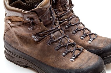 Eski aşınmış yürüyüş botları beyaz arka planda izole edilmiş