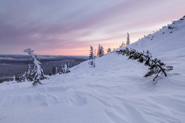 Dağ yamacı taşlarla kışın kar tarafından kaplıdır