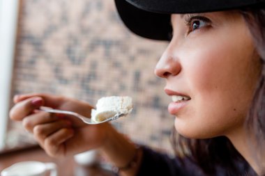 kız beyaz pasta ve gülümseyen bir kaşıkla tutar