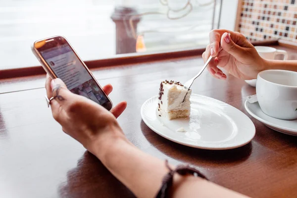 El ve cheesecake kafede telefon — Stok fotoğraf