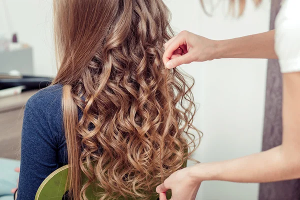 As mãos da trança de cabeleireiro cabelo longo direto no fundo de — Fotografia de Stock