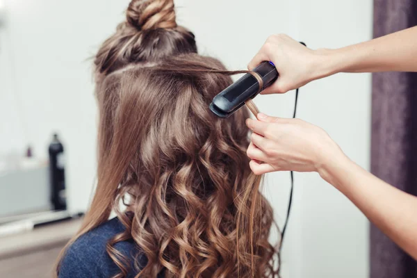Парикмахер работает с красивой женщиной каштановые волосы в парикмахерской — стоковое фото