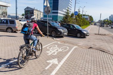 Ufa, Rusya Federasyonu - 2016 olabilir: kadın bisikletçi bisiklet yolu ile araba sokaklara paralel üzerinde sürmek. Kavramı kentsel ulaşım ve trafik