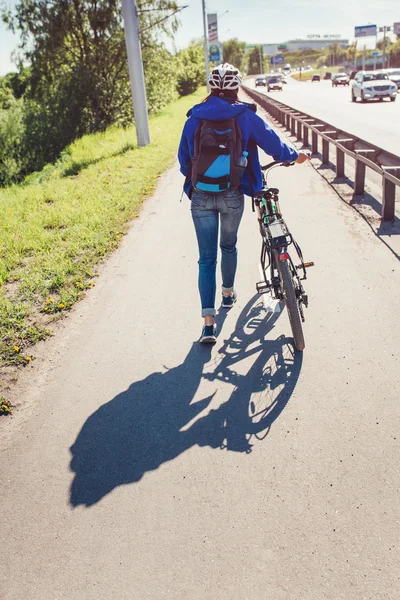 Mädchen mit Fahrrad läuft auf Fußweg am Gehweg der Stadtstraße — Stockfoto