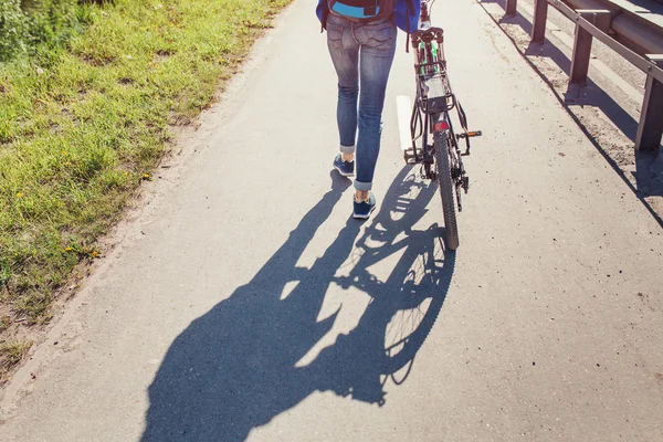 Mädchen mit Fahrrad läuft auf Fußweg am Gehweg der Stadtstraße — Stockfoto