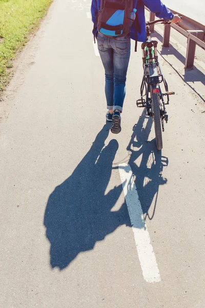 Mädchen mit Fahrrad läuft auf Fußweg am Gehweg der Stadtstraße — Stockfoto