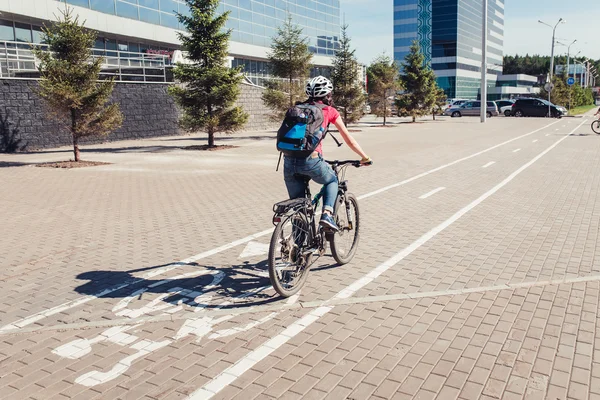 UFA, Russia - MAY 2016: female cyclist rides on the bike path parallel to streets with cars. The concept of urban transport and traffic — Stock Photo, Image