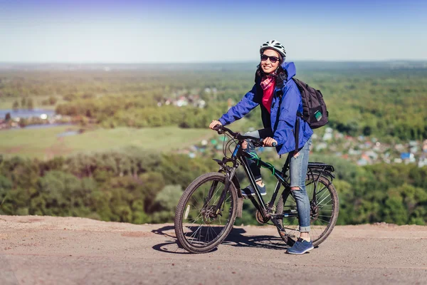 Junge Radfahrerin mit Rucksack und Helm im Park unterwegs — Stockfoto