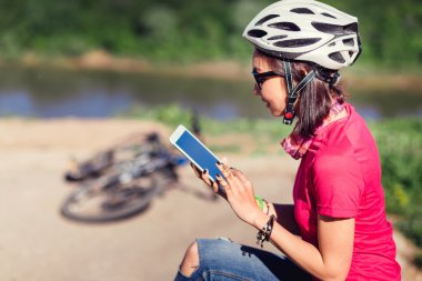 Genç kadın onu bisiklet yanında oturan dijital tablet pc kullanarak uygun