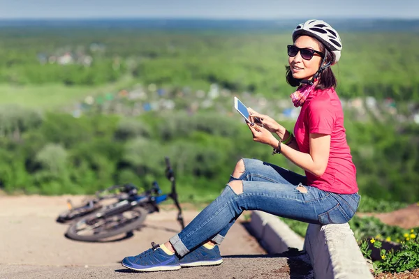 Sporty woman going to work by bicycle speaking phone in country