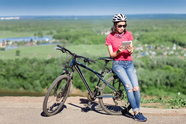 Sport bright girl with helmet sitting with digital tablet pc in