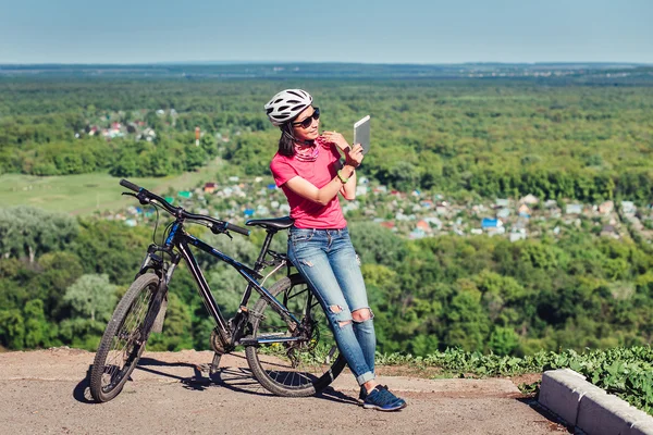 Sport helle Mädchen mit Helm sitzt mit digitalen Tablet-PC in — Stockfoto