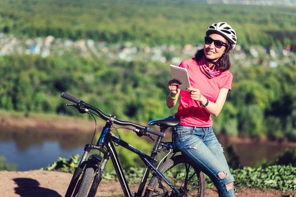 Sport bright girl with helmet sitting with digital tablet pc in