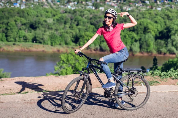 Kask rowerowy - kobieta stawianie rowerowe kask na podczas jazdy rowerem — Zdjęcie stockowe