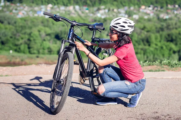 Frau repariert ihr Fahrrad auf dem Land — Stockfoto