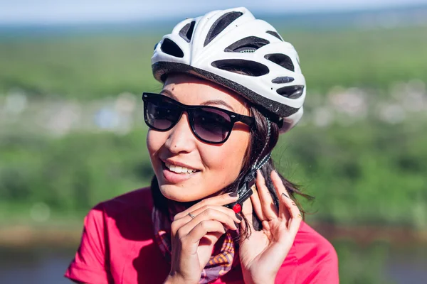 Bike helmet - woman putting biking helmet on during bicycle ride — Stock Photo, Image