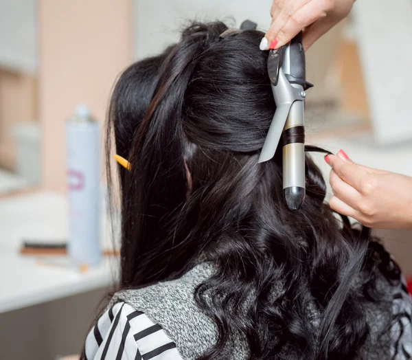 Le coiffeur fait une coiffure de soirée ou de mariage avec un long beaut — Photo