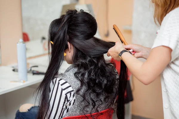 Bir akşam veya düğün saç modeli ile uzun güzel Kuaför yapar — Stok fotoğraf