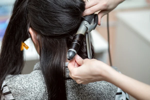 Le coiffeur fait une coiffure de soirée ou de mariage avec un long beaut — Photo