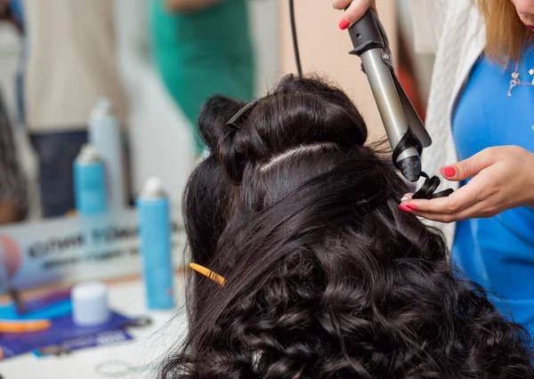 Styliste dans salon de coiffure en fer à friser pour cheveux bruns — Photo